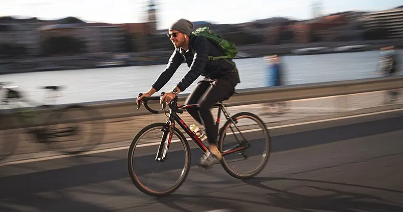 Homem branco com touca andando de bicicleta