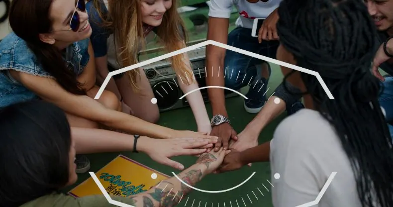 Grupo de jovens com as mãos unidas em círculo, simbolizando trabalho em equipe.