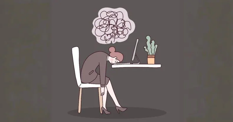 : Empregado exausto sentado à mesa de trabalho