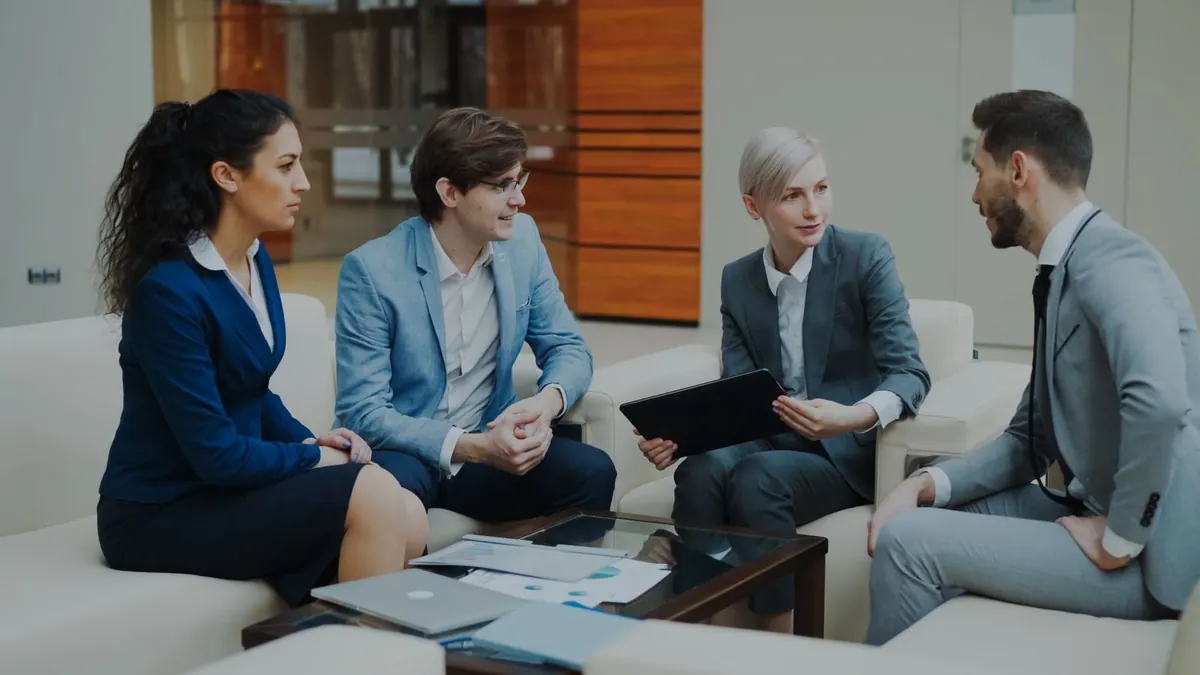 Executivos de RH em uma reunião de negócios, discutindo em um ambiente moderno.