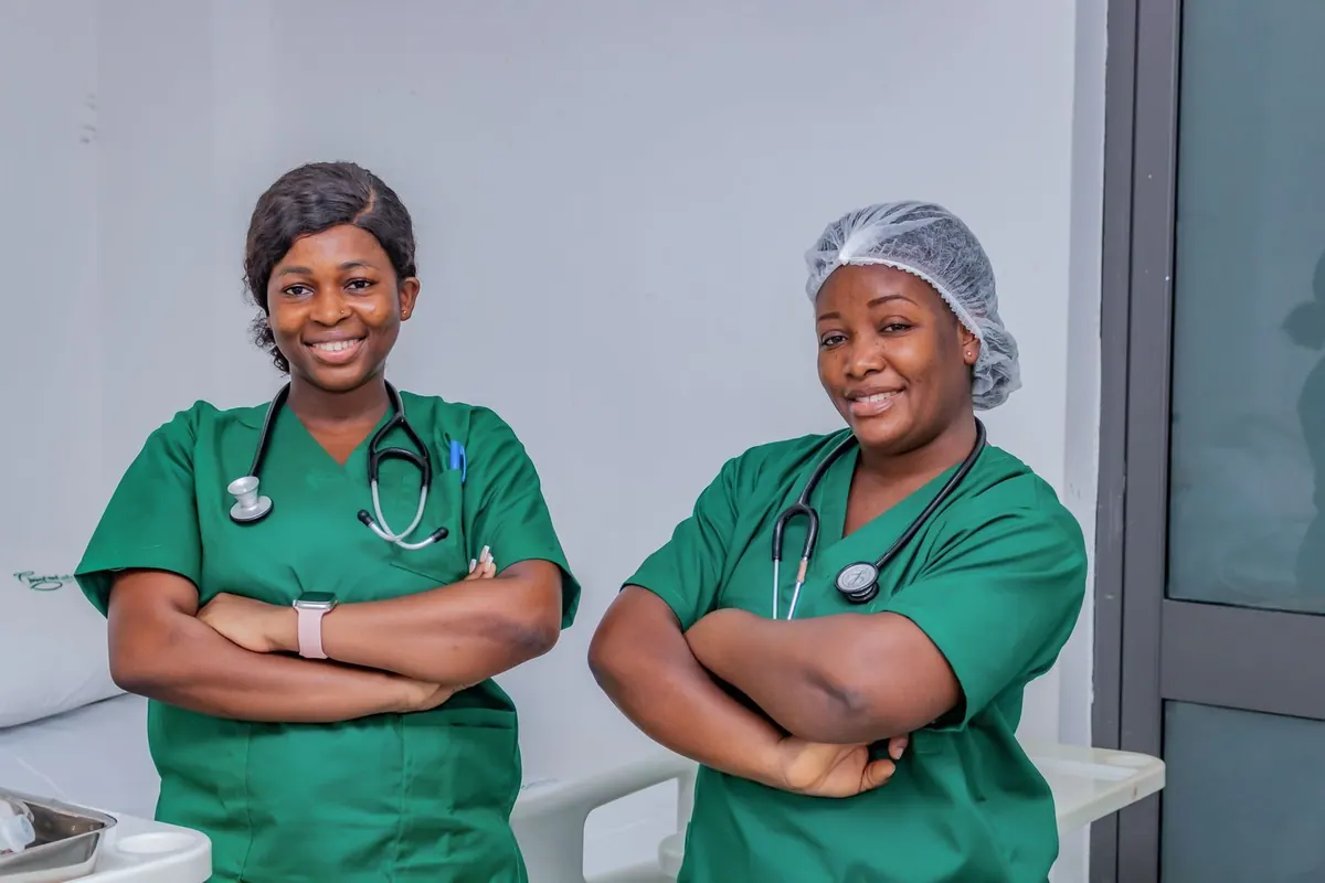 Duas enfermeiras sorrindo em um ambiente hospitalar.