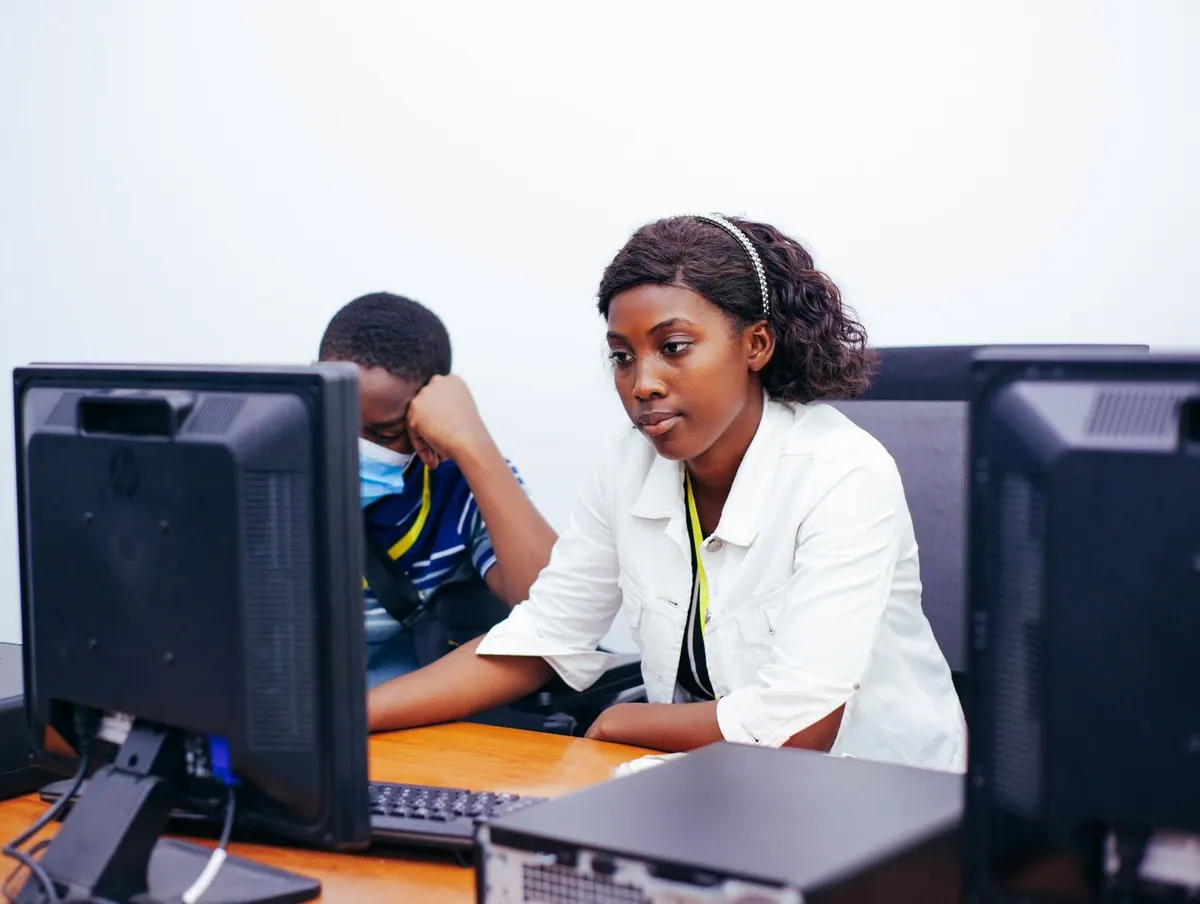 Alunos do ensino médio aprendendo habilidades técnicas e comportamentais em computadores.