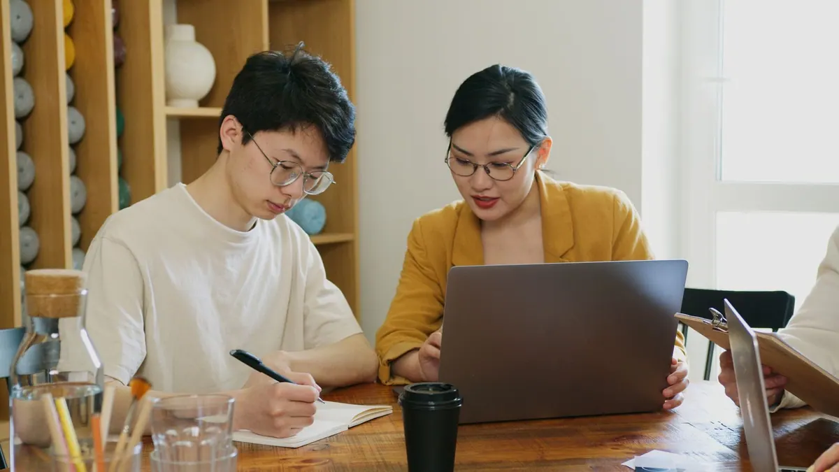 Homem e mulher jovens trabalhando juntos em um escritório moderno.