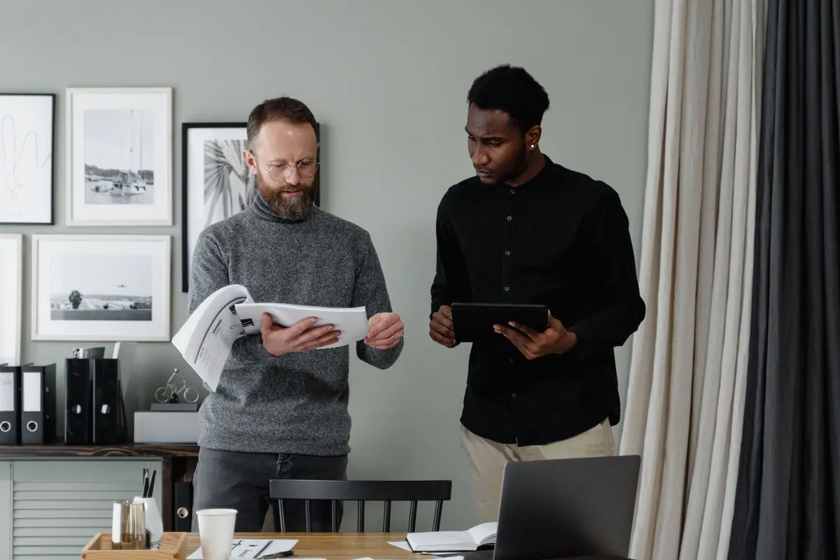 Dois homens de negócios revisando documentos em um escritório.