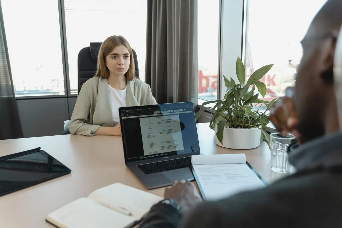 Candidata em entrevista de emprego com recrutador, focando em atração e seleção.