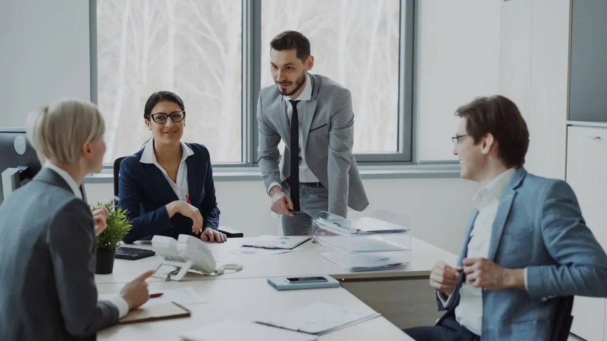 Pessoas em uma reunião de negócios, discutindo projetos em um escritório moderno.