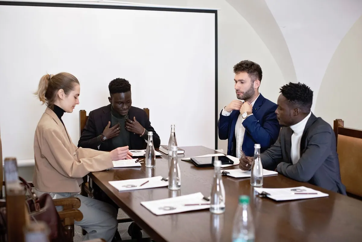 Pessoas em reunião de negócios, discutindo documentos em uma mesa de conferência.