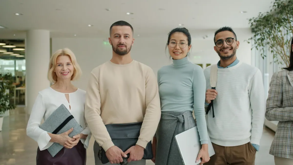 Grupo diverso de profissionais em um escritório moderno, olhando para a câmera.