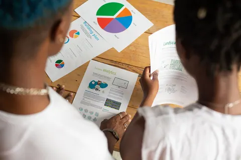 Colegas de trabalho analisando diagramas e planos de negócios em uma mesa.