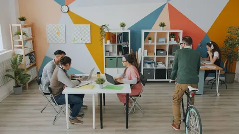 Equipe diversa trabalhando em um espaço de coworking moderno e colorido.
