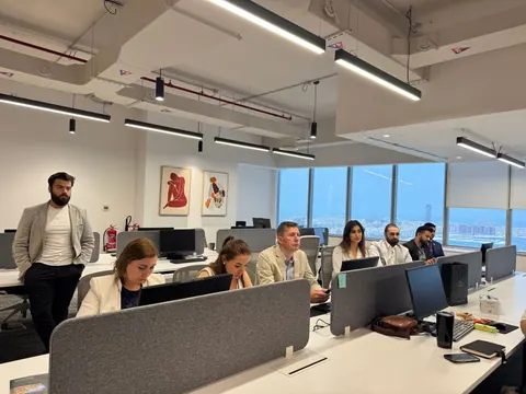 Equipe diversa em escritório moderno, trabalhando em um ambiente colaborativo.