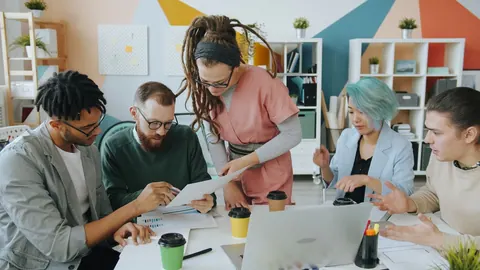 Equipe diversa colaborando em um escritório criativo, com foco na interação e cuidado.