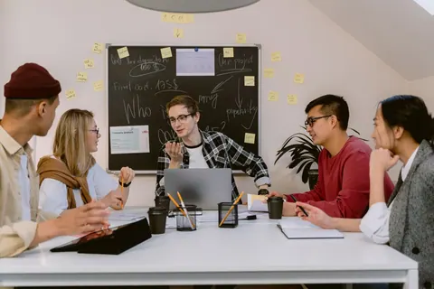 Jovens profissionais em uma reunião de equipe, discutindo ideias em um ambiente colaborativo.
