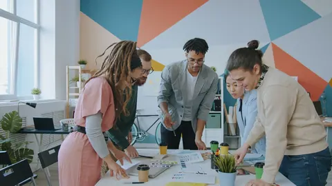 Equipe diversa colaborando em um escritório moderno, discutindo documentos e ideias.