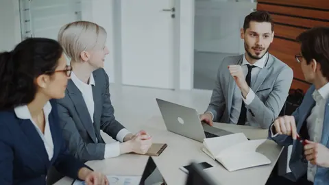 Profissionais em reunião de negócios discutindo em um escritório moderno.