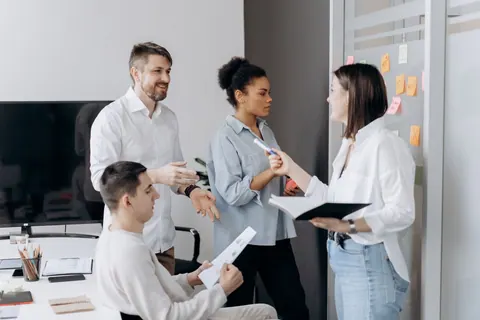 Pessoas diversas em um escritório moderno, colaborando em uma reunião de equipe.