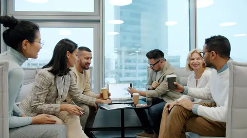 Equipe diversa em reunião de negócios, colaborando e sorrindo em ambiente moderno.