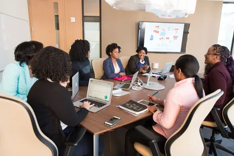 Grupo de mulheres profissionais em uma reunião de negócios, discutindo ideias.