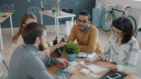 Equipe diversa em reunião colaborativa, demonstrando escuta ativa e empatia.