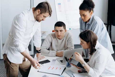 Equipe de RH analisando dados e gráficos em reunião de trabalho.