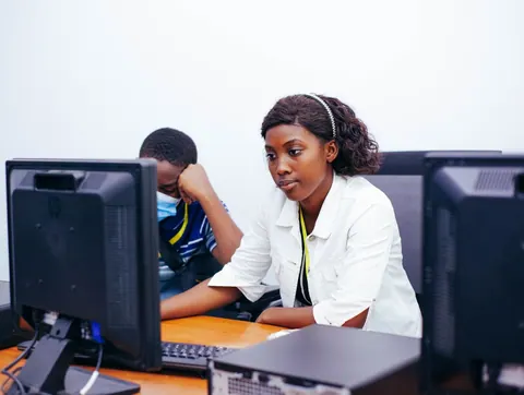 Alunos do ensino médio aprendendo habilidades técnicas e comportamentais em computadores.