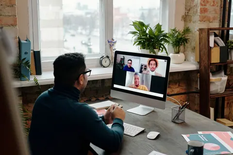 Homem em casa participando de uma reunião online com colegas de trabalho.