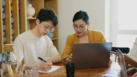 Homem e mulher jovens trabalhando juntos em um escritório moderno.