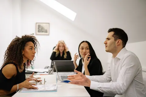Pessoas de diversas etnias e gêneros discutindo em uma reunião de negócios.