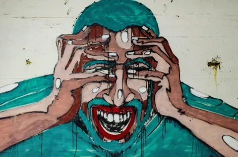 Pintura de um rosto angustiado com as mãos na cabeça e boca aberta.