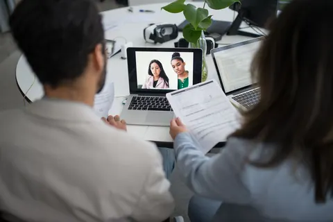 Profissionais de RH em entrevista de emprego online, focando em soft skills.