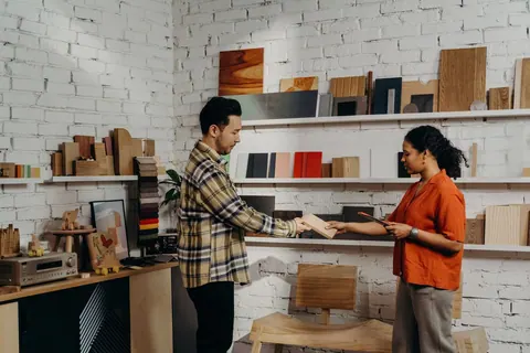 Funcionário da loja de materiais de construção ajudando cliente a escolher amostra.