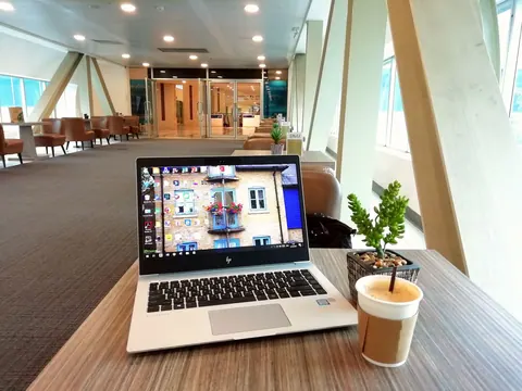 Laptop em um ambiente de trabalho moderno e acolhedor, com elementos residenciais.