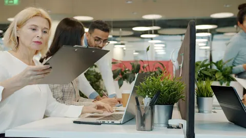 Equipe diversa colaborando em um escritório moderno, focada em suas tarefas.