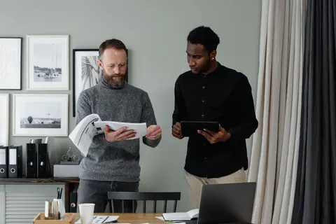 Dois homens de negócios revisando documentos em um escritório.