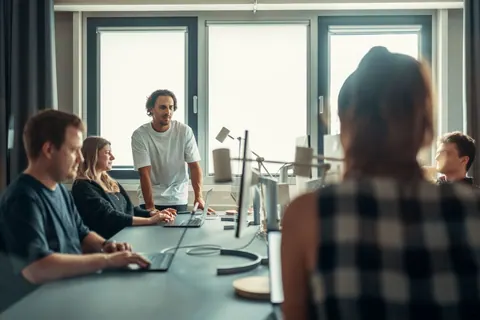Equipe diversa em reunião colaborativa, discutindo ideias em um escritório moderno.