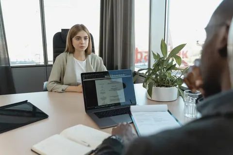 Candidata em entrevista de emprego com recrutador, focando em atração e seleção.