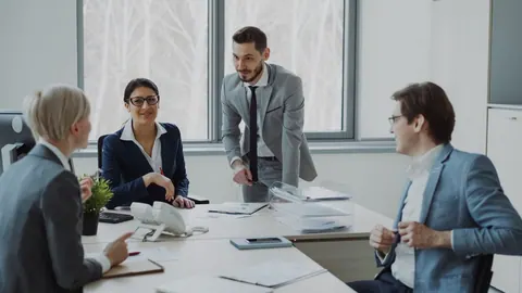 Pessoas em uma reunião de negócios, discutindo projetos em um escritório moderno.
