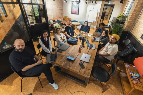 Grupo diverso de profissionais em um ambiente de trabalho moderno e colaborativo.
