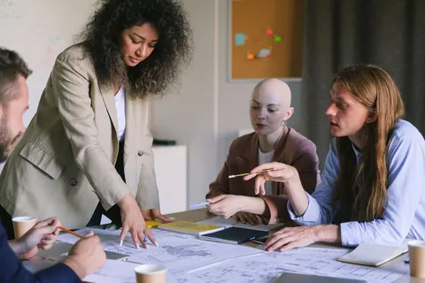 Profissionais diversos em reunião de trabalho colaboram em novas ideias.