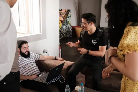 Pessoas de diferentes idades e etnias conversando animadamente em um ambiente de trabalho informal.