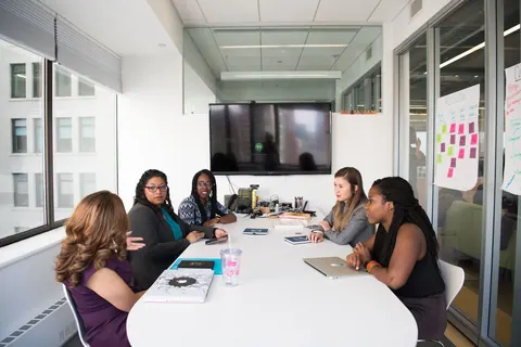Grupo de mulheres profissionais em uma reunião de trabalho em sala de conferência.