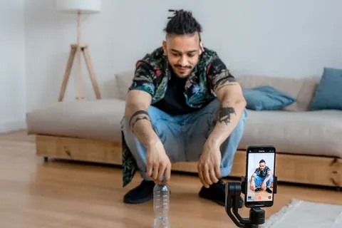 Homem gravando vídeo para TikTok com smartphone em tripé