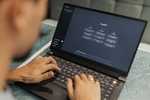 Homem digitando em um laptop com a interface do ChatGPT aberta.