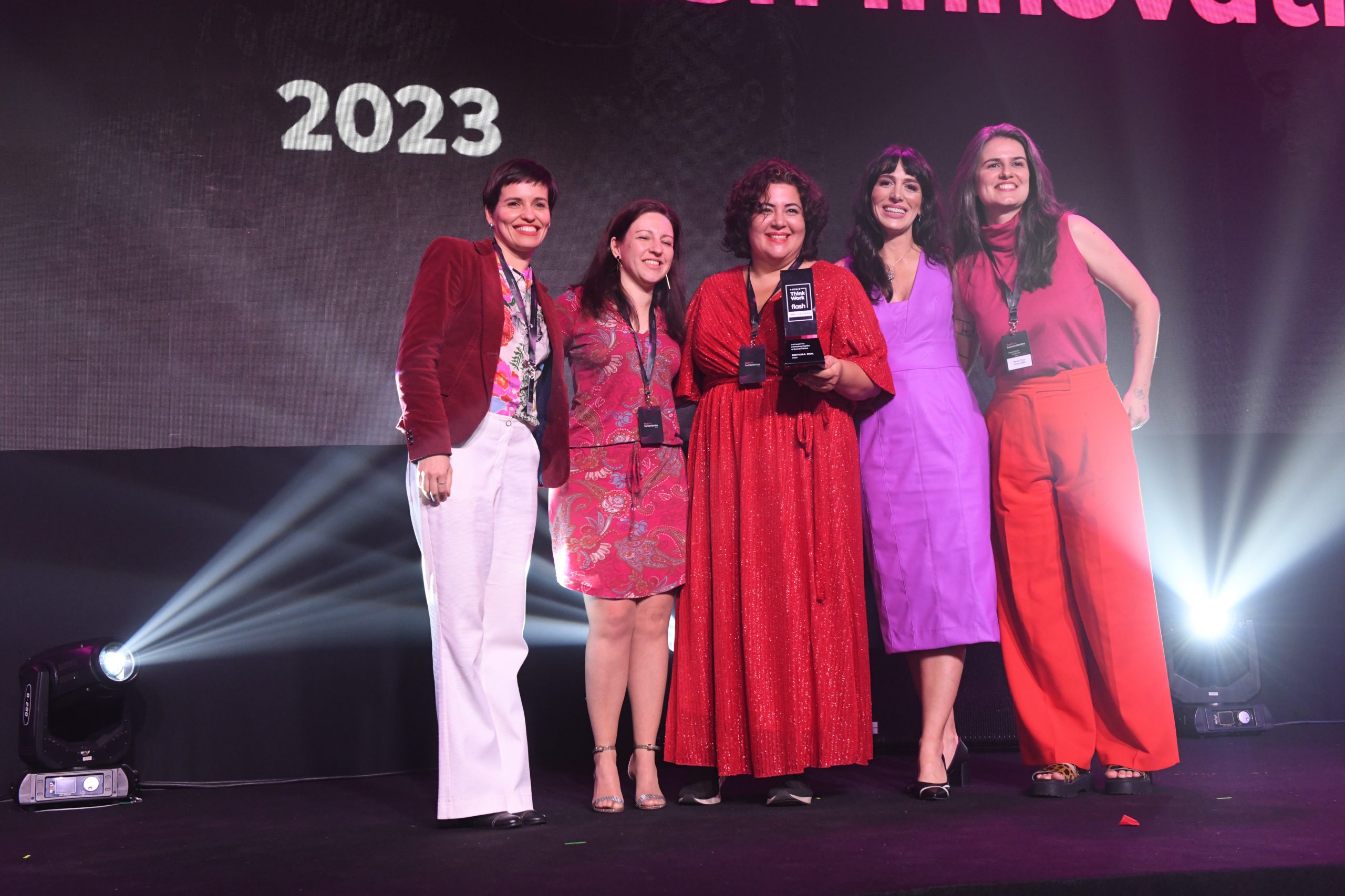 Tatiana Sendin entrega troféu para Roberta Faria, CEO da Editora MOL, e equipe